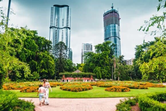 a-mother-and-son-wander-through-the-city-botanic-gardens-with-skyscrapers-in-the-background